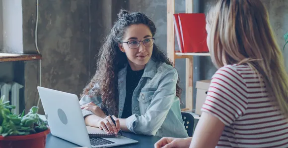 Young female entrepreneur talking to partner in modern office.